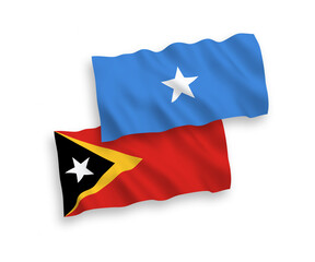 National vector fabric wave flags of East Timor and Somalia isolated on white background. 1 to 2 proportion.