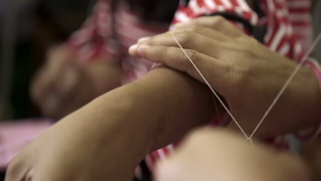 women removing hair using threading at home
