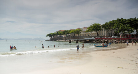 Fototapeta na wymiar Citizens swimming in the ocean. Copacabana Fort