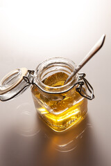 detail of agave syrup in glass jar with spoon inside. White background