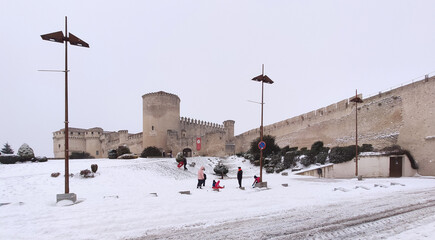Snowfall with children playing next to a castle