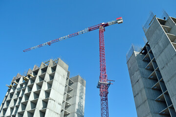 building construction site with tower crane on clear blue sky background