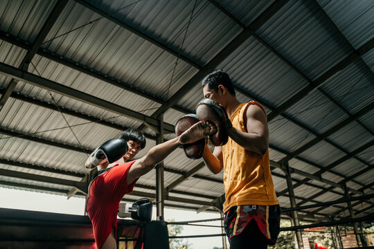 boxer and his coach doing some sparring in ring. Boxer and his coach practicing some moves