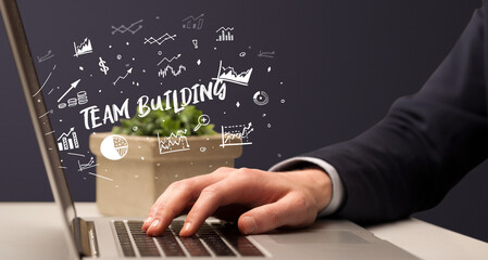 Businessman working on laptop with TEAM BUILDING inscription, modern business concept