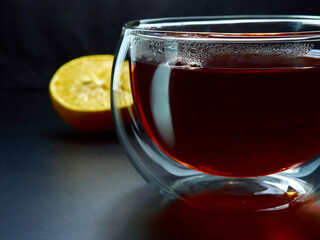 Glass cup with tea close up on dark background