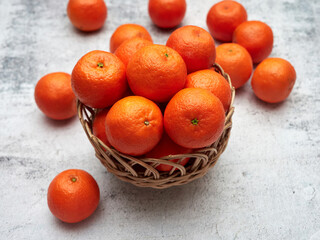Tangerines in a wicker basket on a stone countertop