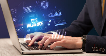 Obraz na płótnie Canvas Businessman working on laptop with DUE DILIGENCE inscription, new business concept