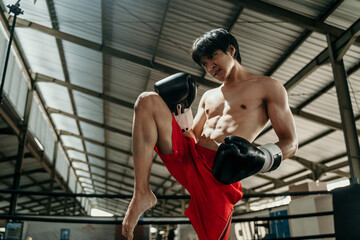 Kickboxer in the ring with the copyspace do stretches before the fight makes swing movements with...