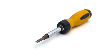 Yellow metallic manual multi-bit screwdriver with replaceable bits. Close-up photo of repair work tool isolated on a white background. Selective focus on a single object.