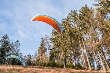 Startender Hobby Gleitschirm Flieger an einem Berghang mit professioneller Ausrüstung im Herbst,...