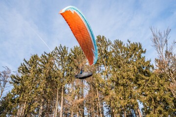 Startender Hobby Gleitschirm Flieger an einem Berghang mit professioneller Ausrüstung im Herbst,...