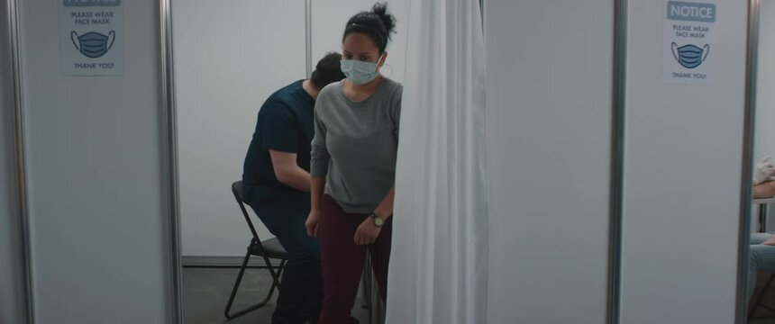 RL DOLLY Doctors administering vaccine to a patients inside temporary vaccination cabins. COVID-19 coronavirus vaccination