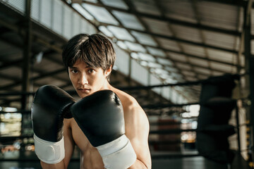 Fototapeta premium ultimate fighter in boxing gloves with movement hands defend beside copyspace on the ring arena
