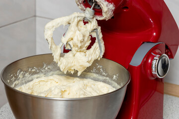 Red Kitchen pastry robot with cream close-up.