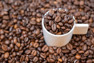 coffee beans close up and a cup full of coffee beans