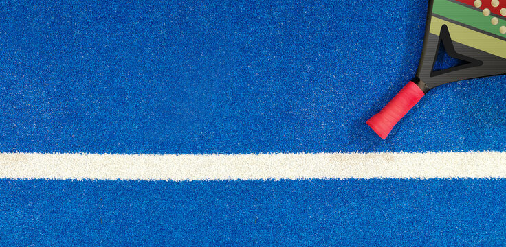 Close up of a padel ball and racket on a blue syntehtic playground	