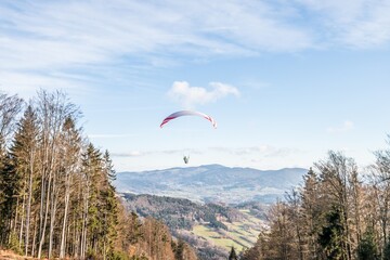 Fliegender Hobby Gleitschirm Flieger an einem Berghang mit professioneller Ausrüstung im Herbst...