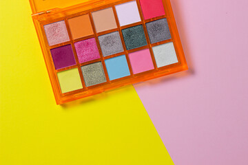A palette of bright cosmetics. Cosmetics on a colored background. Bright eye shadow.