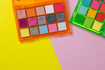 A palette of bright cosmetics. Cosmetics on a colored background. Bright eye shadow.