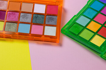 A palette of bright cosmetics. Cosmetics on a colored background. Bright eye shadow.