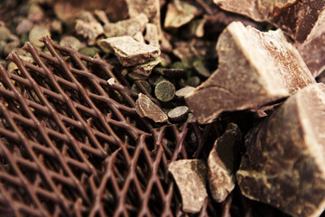 Pieces of chocolate for the production of confectionery. Ingredient in the form of large, unprocessed pieces in various forms for the preparation of sweet dishes. Close-up