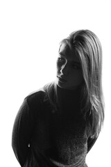 Obraz premium Black and white portrait of a young girl with sparkles on her face in a sweater on a white background