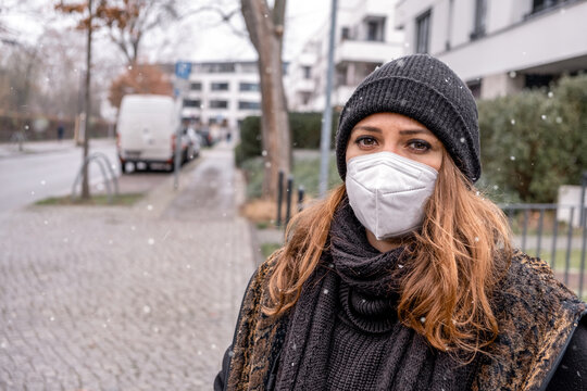 young brunette woman outdoors in the cold wearing a ffps mask