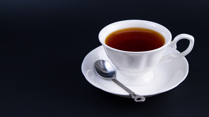 white cup of tea on black background