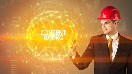 Handsome businessman with helmet drawing CONTENT RATING inscription, social construction concept