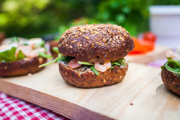 ingredients for making prawn burgers in nature. The table with the checkered tablecloth in the Park