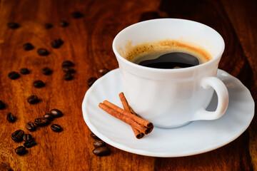 Cup with coffee with cinnamon sticks