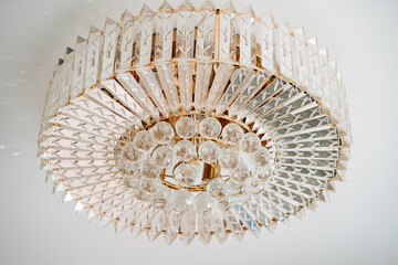 glass round chandelier on the white ceiling. Home lighting. The interior of a house or restaurant. Interior decor elements.