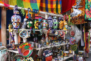Mexican culture - a shelf with folk products on the market. Hand painted vases, mugs, plates, bowls mugs.