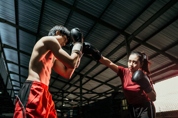 Female boxer with jab motion while competing against male boxer at boxing camp