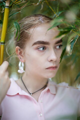 Woman with blonde hair portrait on the background of trees