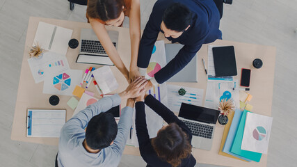 Group of business team people putting their hands together teamwork with a stack of hands showing unity and teamwork.