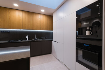 Interior of modern kitchen with built-in appliances in a house
