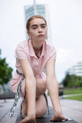 Young girl with blonde hair sitting in city