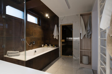 Interior of bathroom with bathtub and sauna in modern house