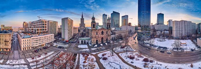Beautiful panoramic aerial drone view on All Saints Church - Roman Catholic church located at Grzybowski Square, Warsaw City Skyscrapers, PKiN, and Varso Tower under construction. Warsaw, Poland