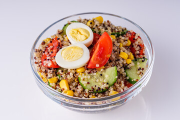 bowl of healthy quinoa with vegetables on a white background
