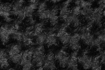 Black hairy shaggy fur. Swirl fur texture. Winter jacket underlay as a background