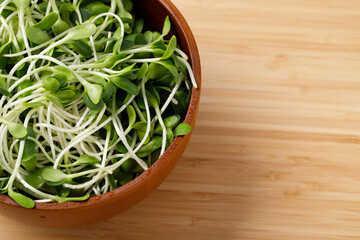 Organic sunflower sprouts placed on a wooden plate ready to cook in the kitchen