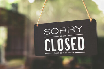 sorry closed sign on shop door. Text on cafe front or restaurant hang on door at entrance. vintage tone style.