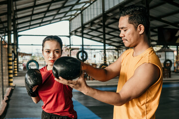Trainer with a woman boxer standing together during a training