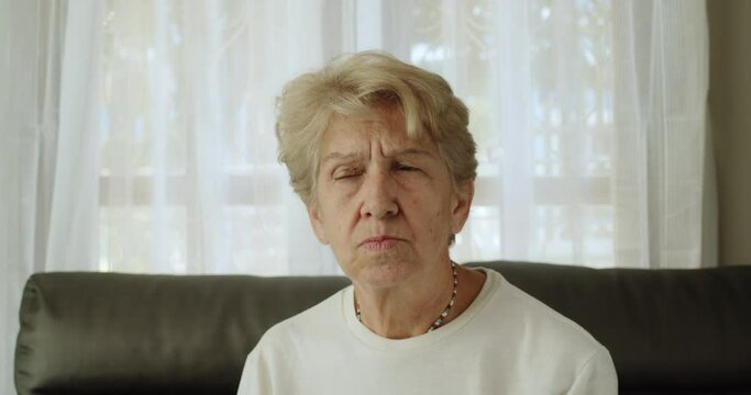 An elderly woman after retirement cut short hair with white and bronze hair wearing long sleeve T-shirt and a necklace, show a face of rejection, dissatisfaction, disagreement.