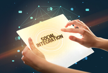 Holding futuristic tablet with SOCIAL INTEGRATION inscription, social media concept