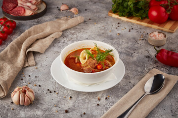 Hot soup with meat and vegetables, textured background