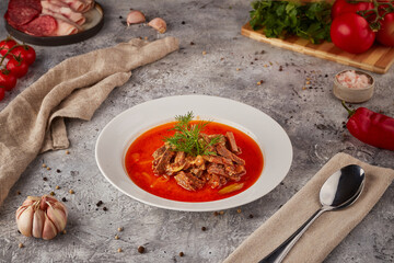 Hot soup with meat and vegetables, textured background