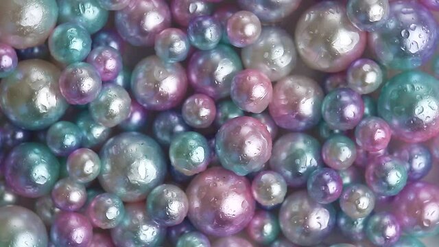 Mother-of-pearl wet multi-colored pearls as a background wrinkles in a circle. Seafood gems.